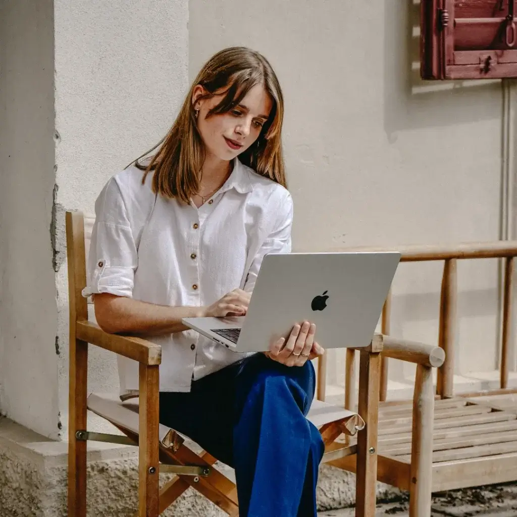 Ann-Kathrin Spöri arbeitet mit ihrem Laptop auf einer Terasse - Social-Media-Agentur-B2B-#12